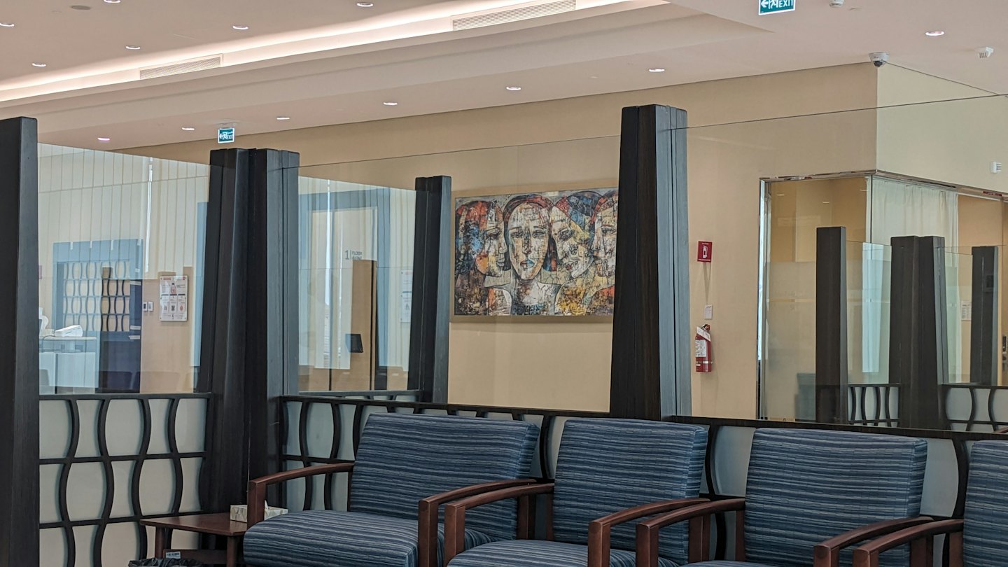 Leerer moderner Warteraum mit gestreiften Sesseln und abstrakter Kunst.
